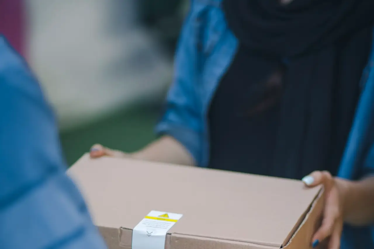 Hands taping a shipping box